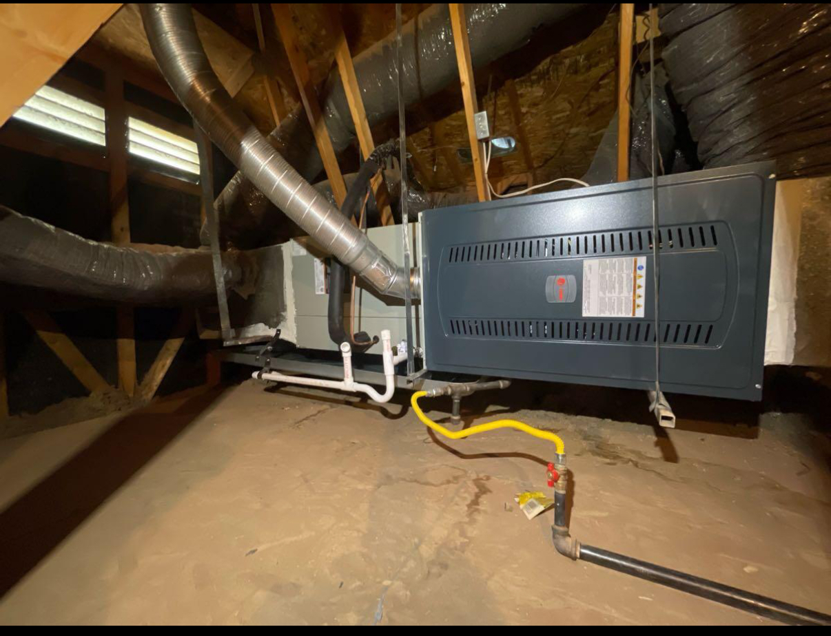 An air conditioner is installed in the attic of a house.
