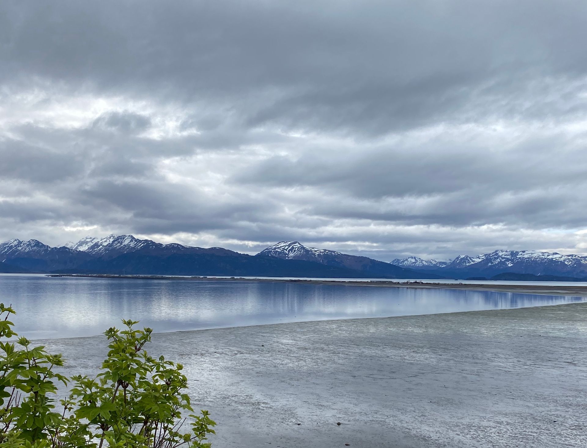 A lake with mountains in the background on a cloudy day