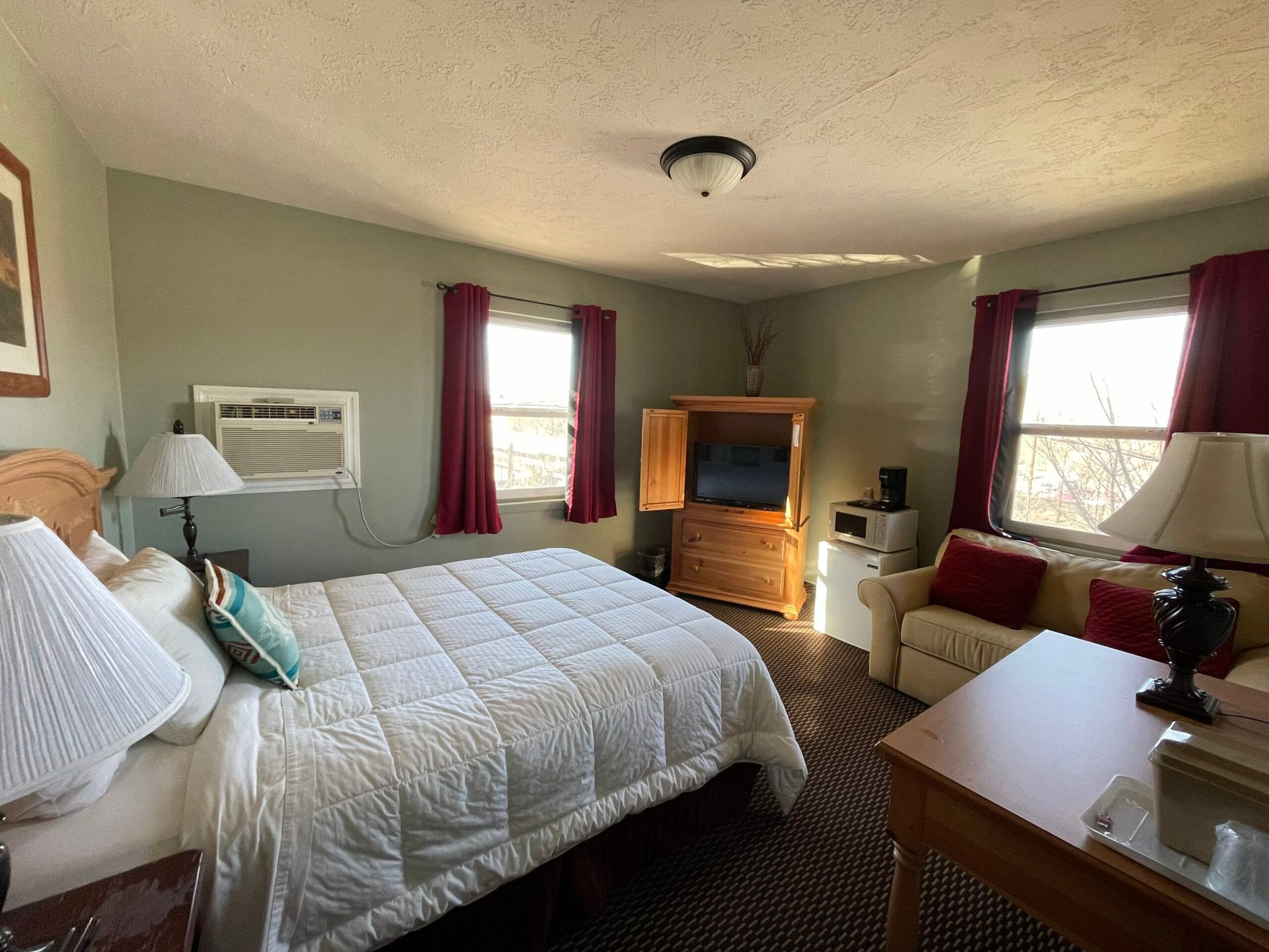 A hotel room with a bed , couch , table and television.