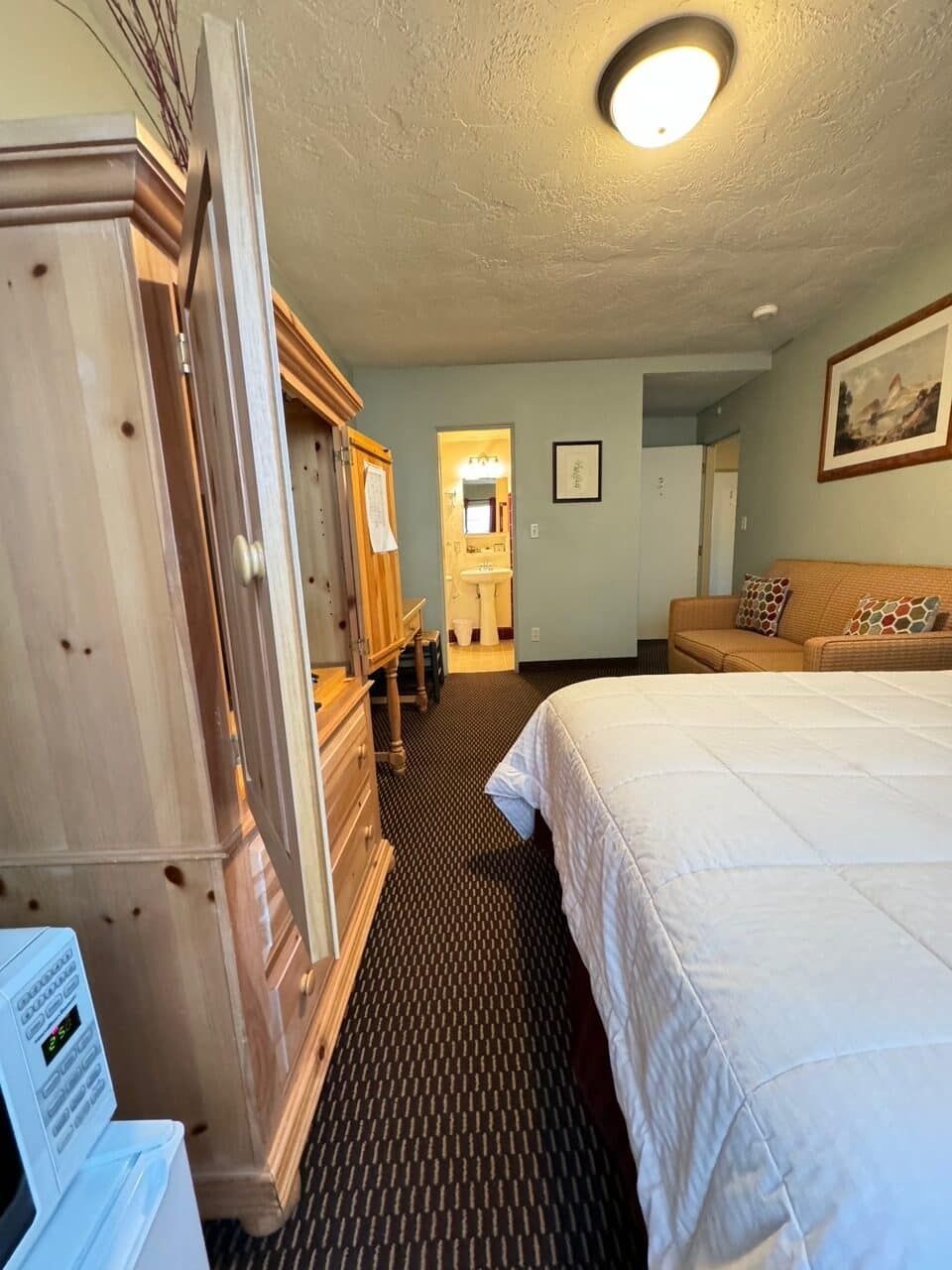 A hotel room with a king size bed and a couch