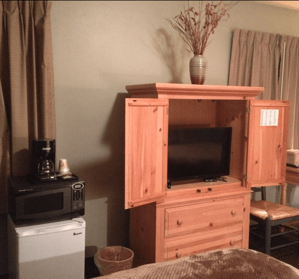 A room with a dresser and a flat screen tv