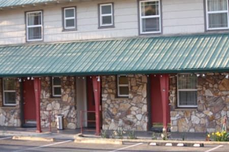 A motel with a green roof and a stone wall