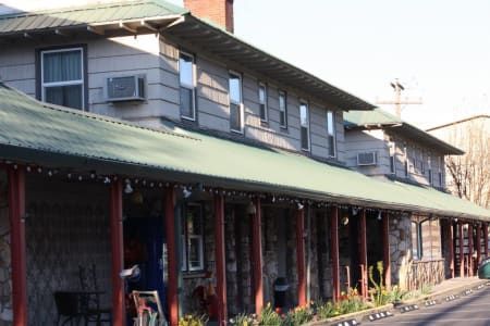 A large building with a green roof and a long porch