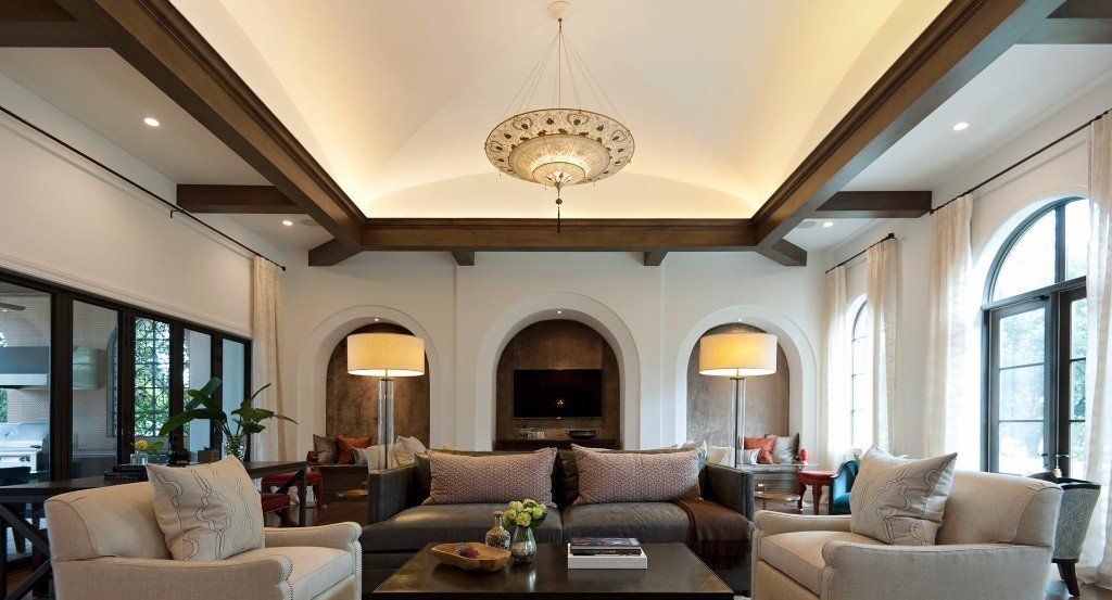 Living room with coved ceilings, uplights reflecting off ceiling and center chandelier