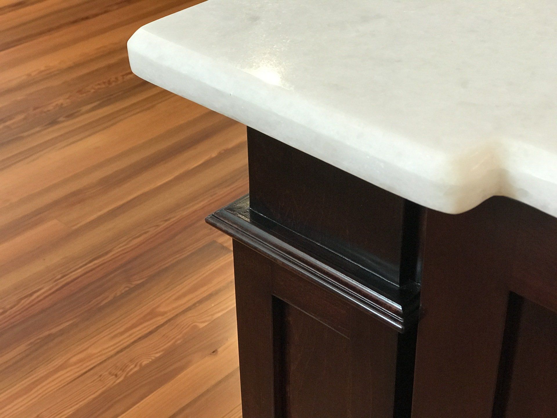 Beveled white marble counter edge with custom cabinet and hardware floor