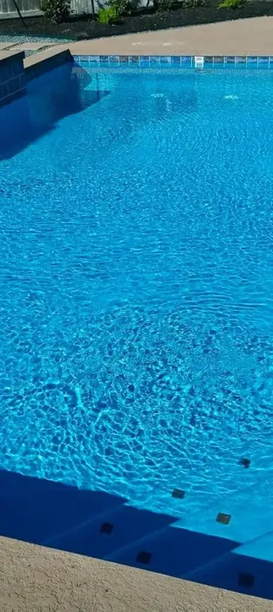 A person is taking a picture of a large swimming pool.