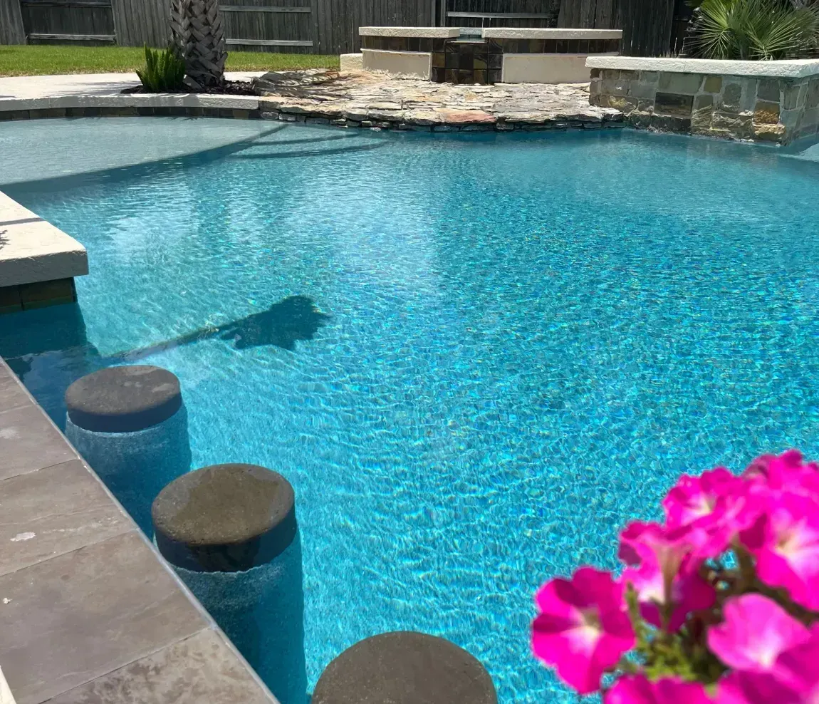 A man is standing in the middle of a swimming pool under construction.
