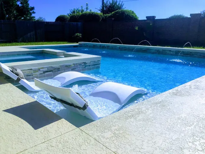 A swimming pool with a few chairs in it