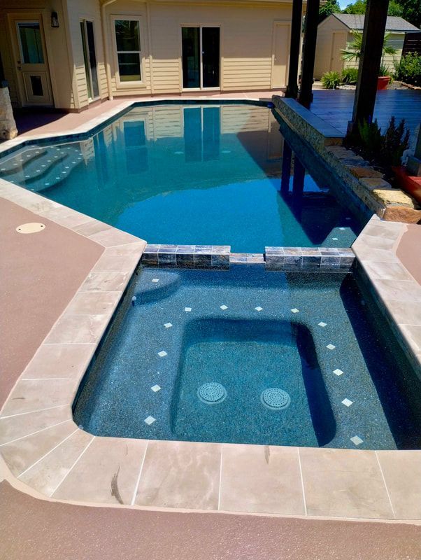 A large swimming pool with a hot tub in the middle