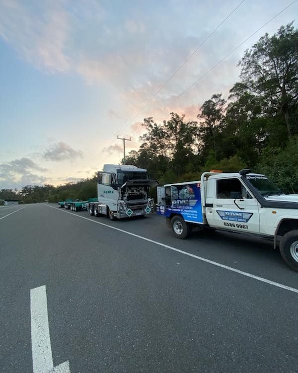 A Truck and a Tow Truck Are Parked on the Side of the Road — BDM Heavy Vehicle Repairs In Wauchope, NSW