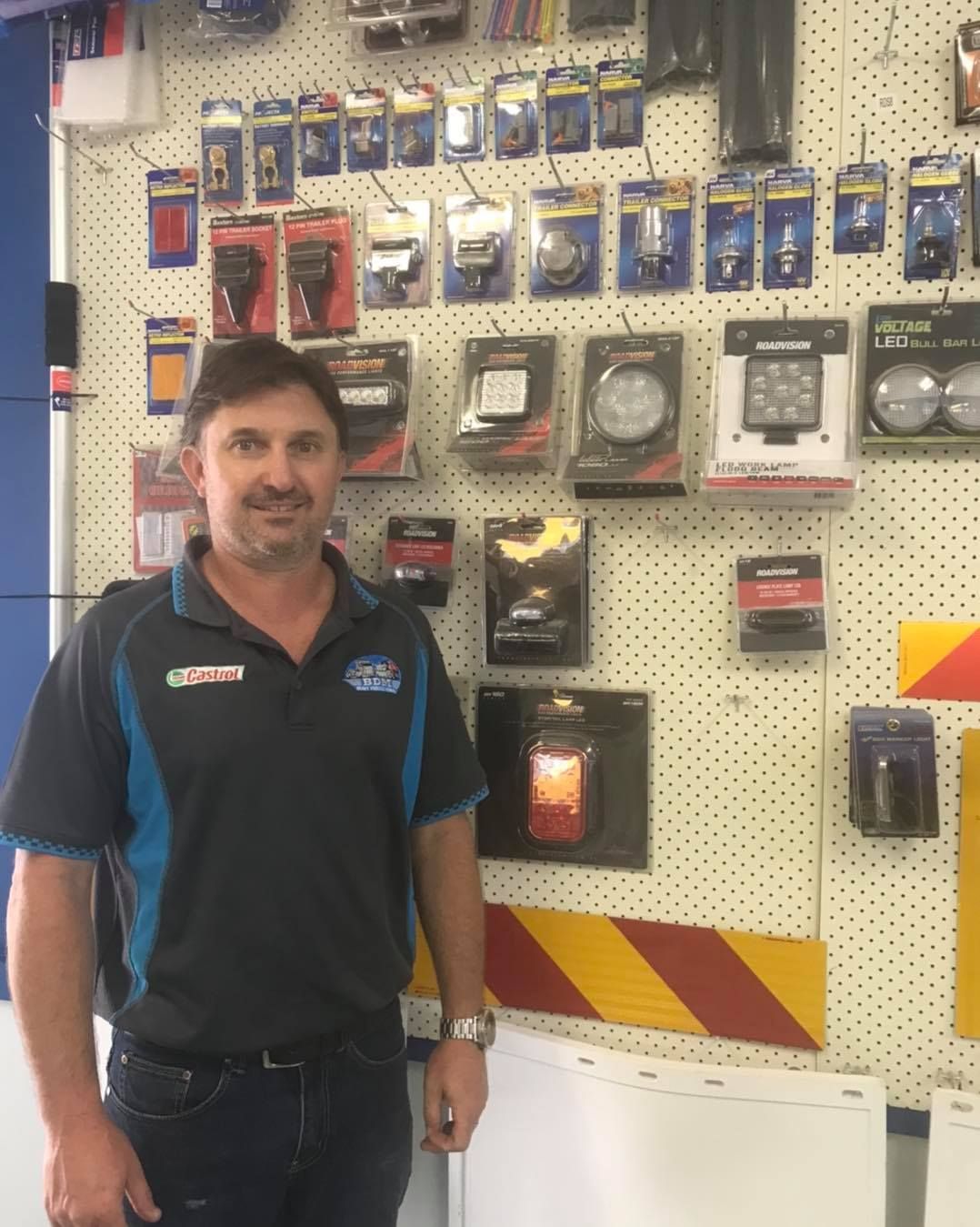 A Man is Standing in Front of a Wall Full of Products — BDM Heavy Vehicle Repairs In Port Macquarie, NSW