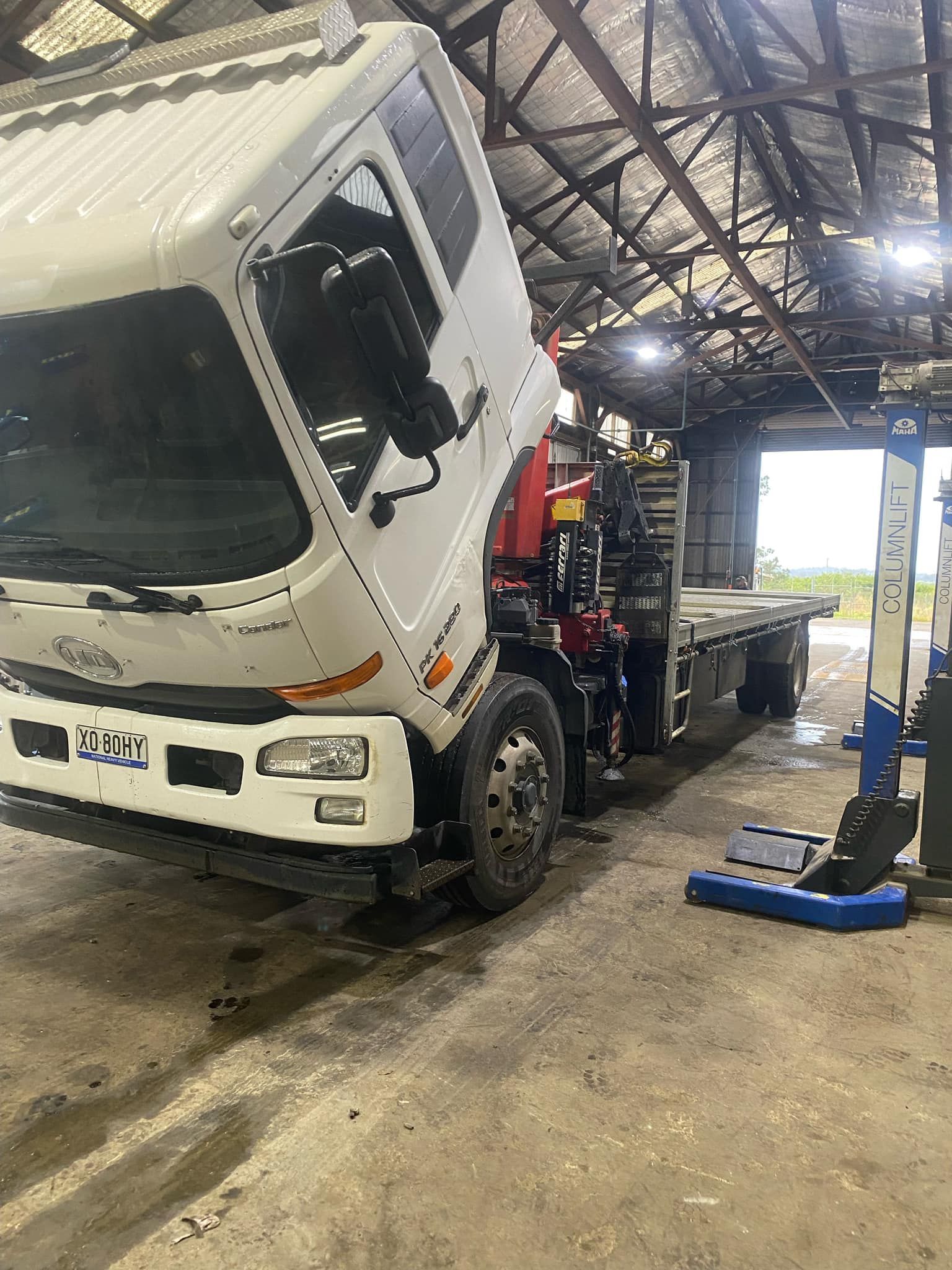 A white truck is sitting on a lift in a garage.— BDM Heavy Vehicle Repairs In Wauchope, NSW