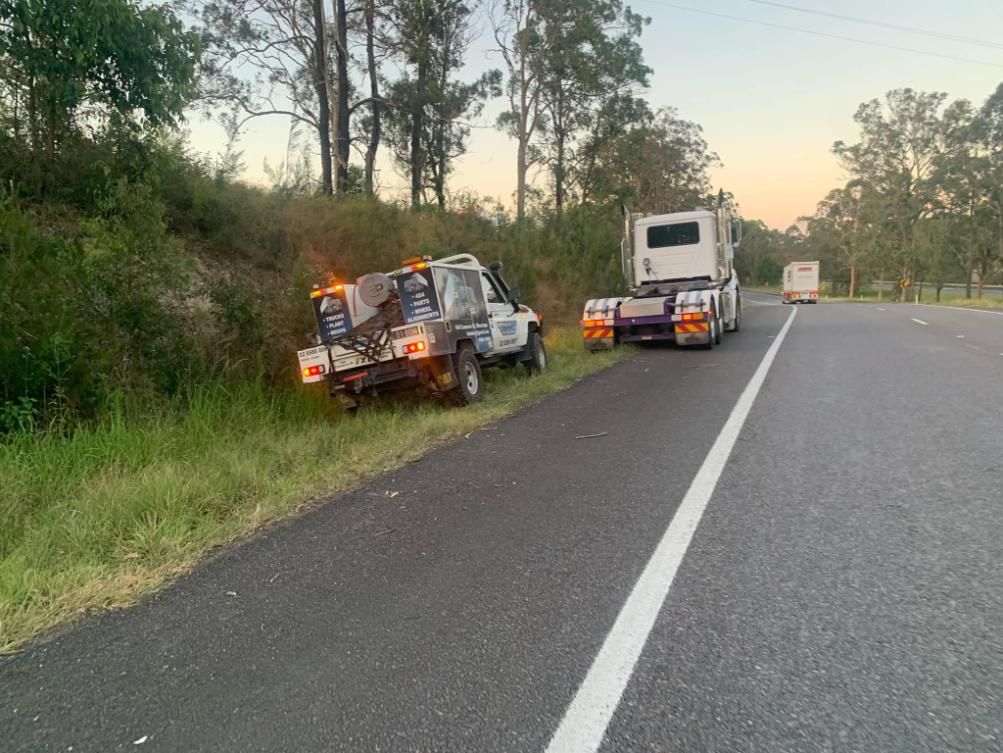 A Tow Truck is Parked on the Side of the Road Next to a Truck — BDM Heavy Vehicle Repairs In Taree, NSW