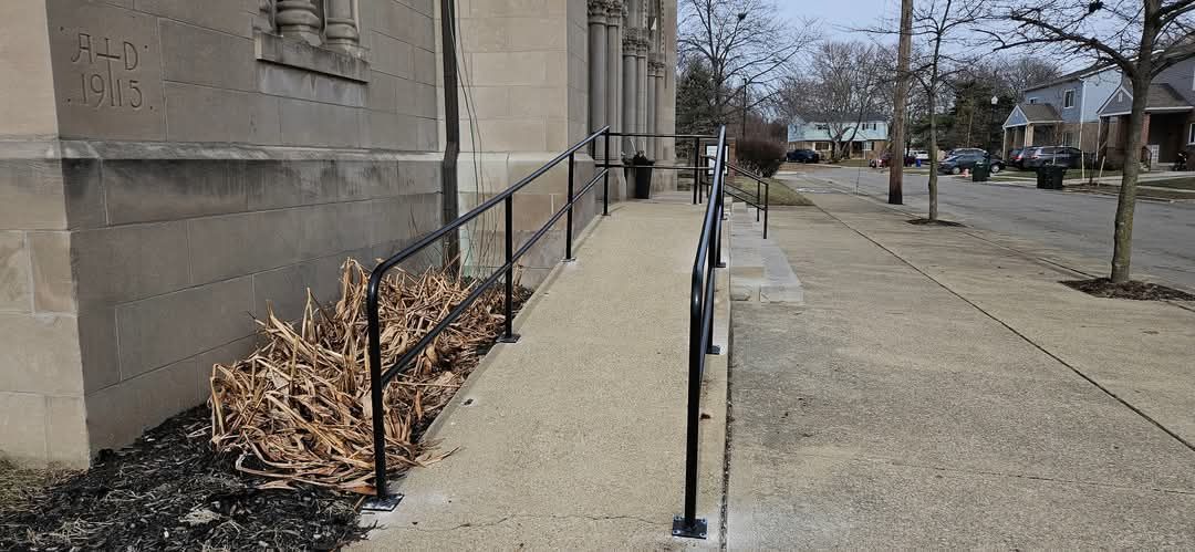 A sidewalk with a railing on the side of a building.