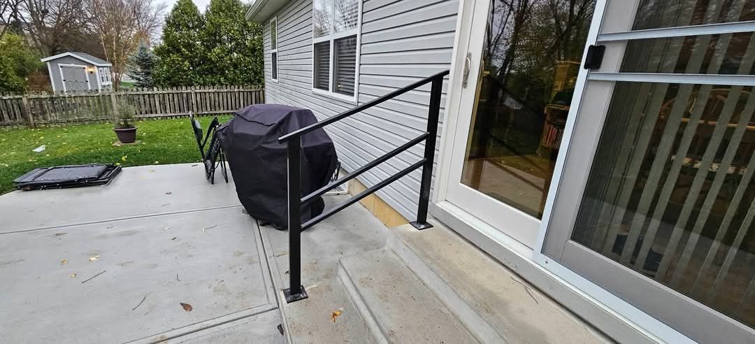 A metal railing is attached to the side of a mobile home.