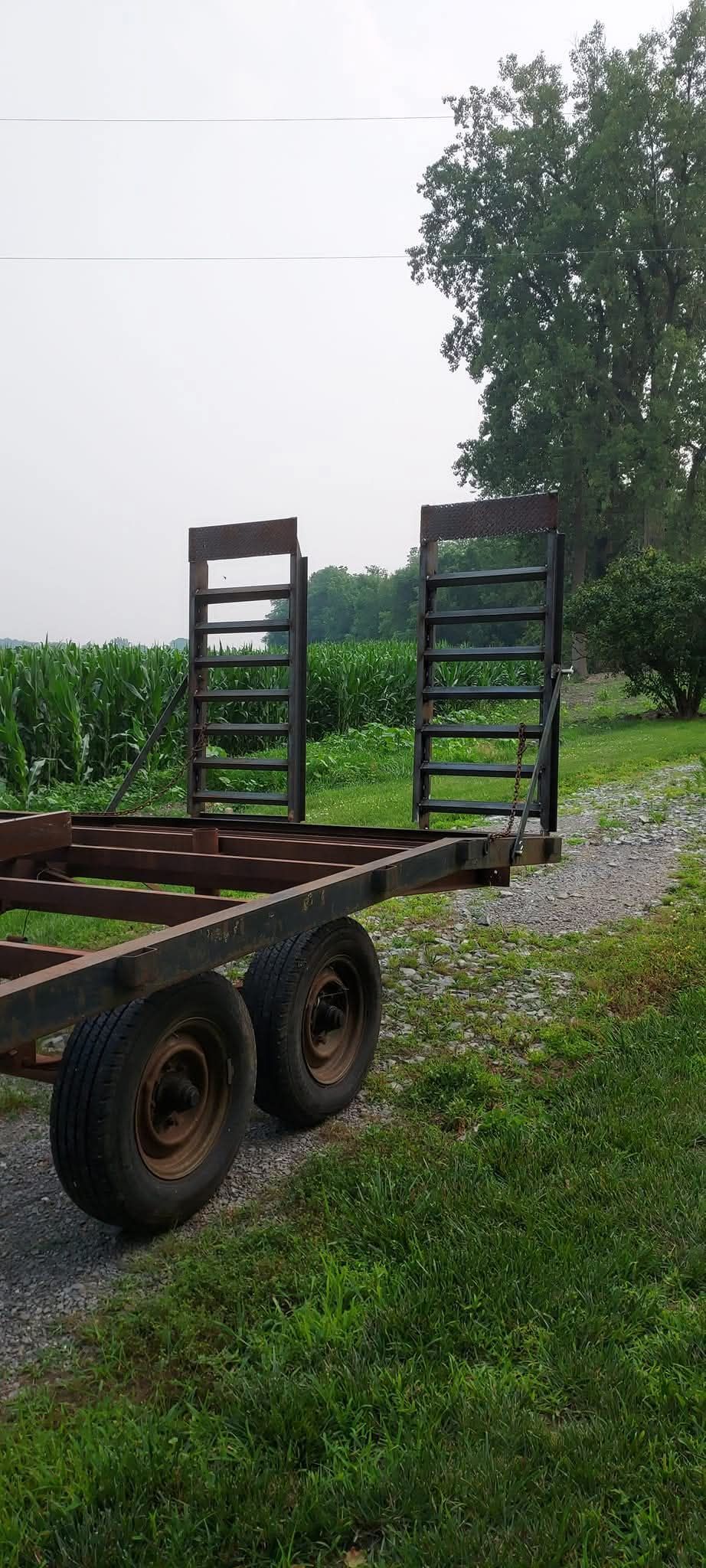 A trailer is parked in the grass in a field.