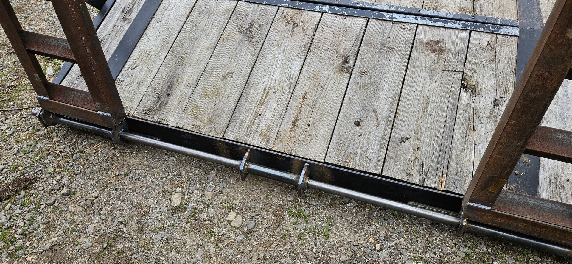 A close up of a wooden platform with a metal chain attached to it.