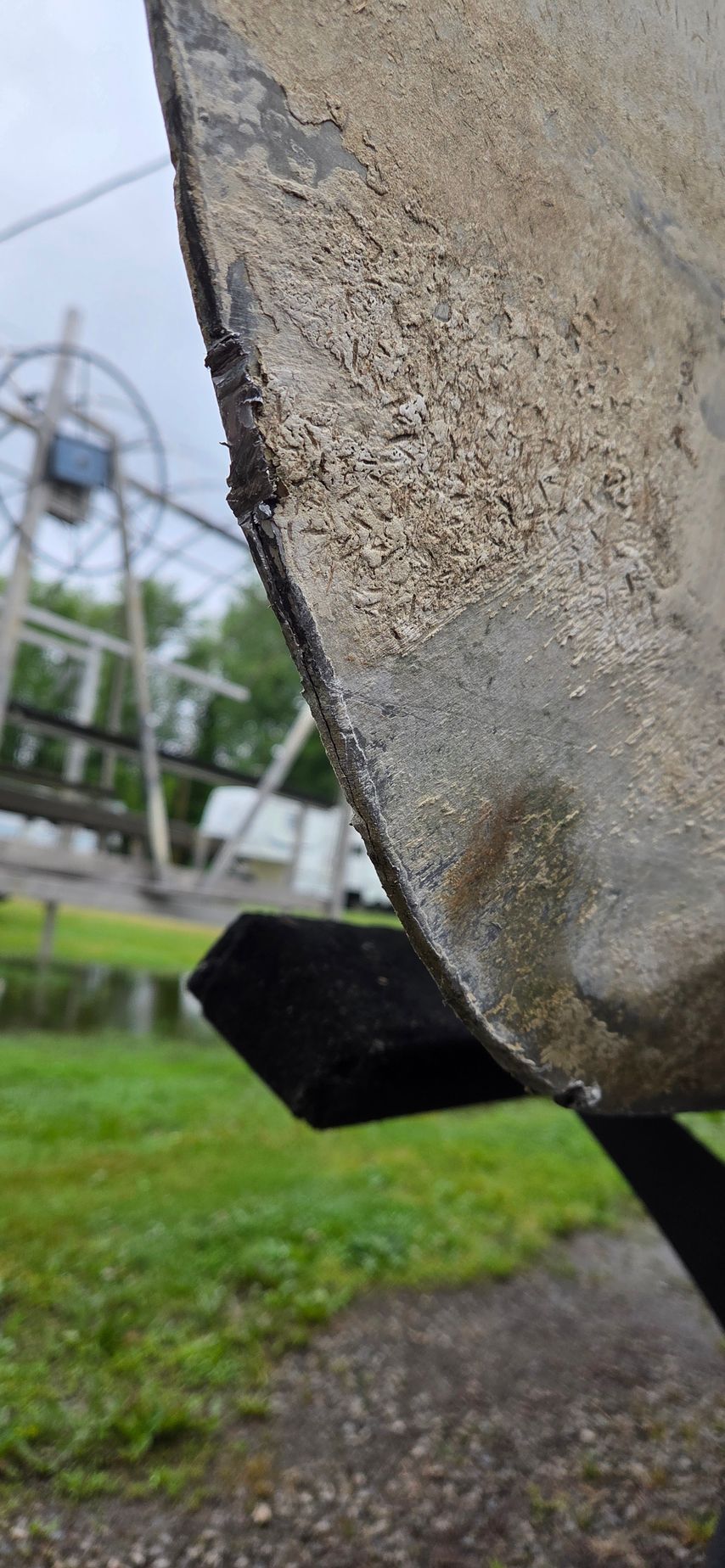 A close up of a concrete sculpture in a park with a ski lift in the background.