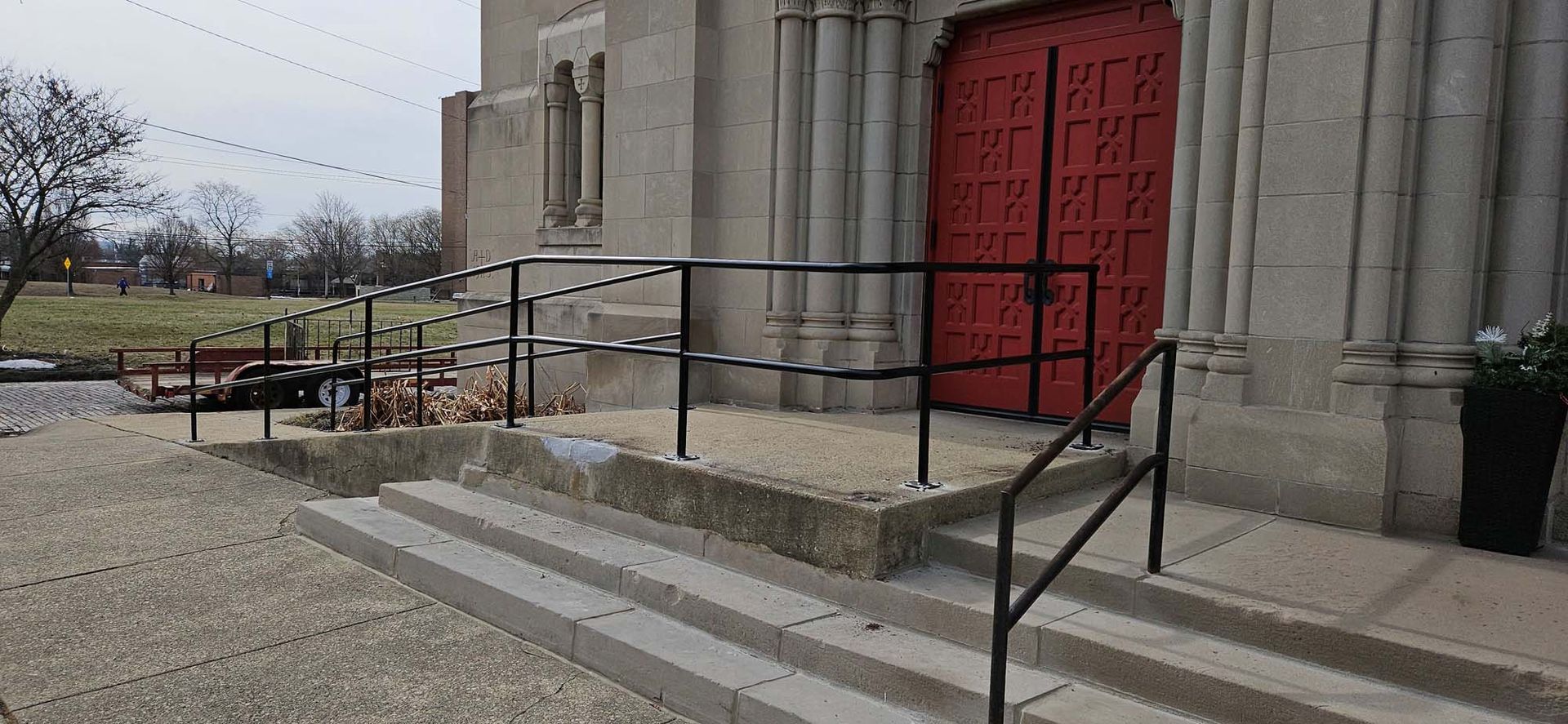 A church with a red door and stairs.