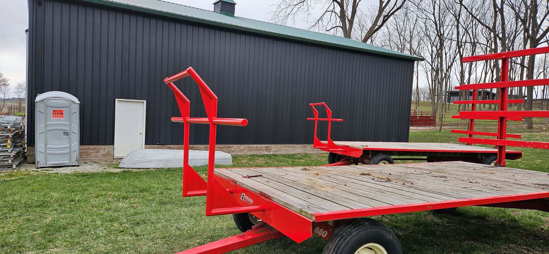 A red trailer is parked in front of a black building.