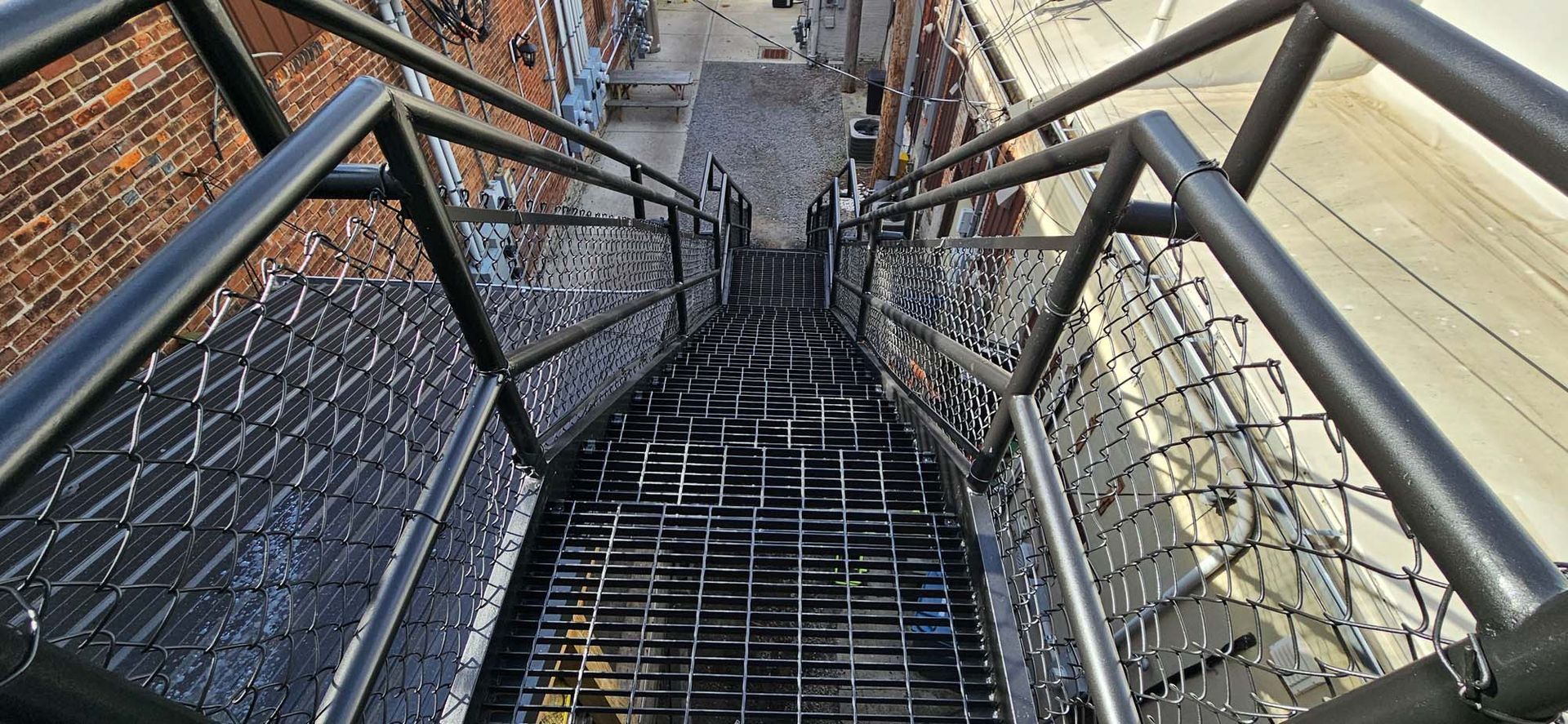 A set of stairs leading up to a building with a chain link fence.
