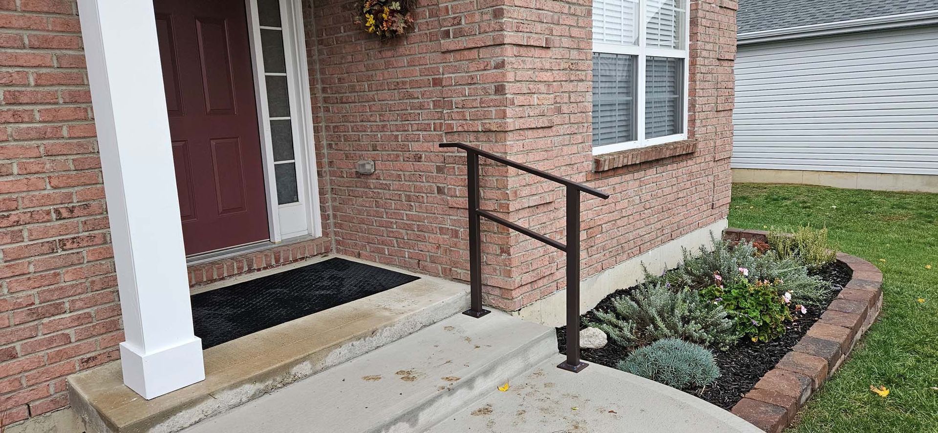 A brick house with a ramp leading to the front door.