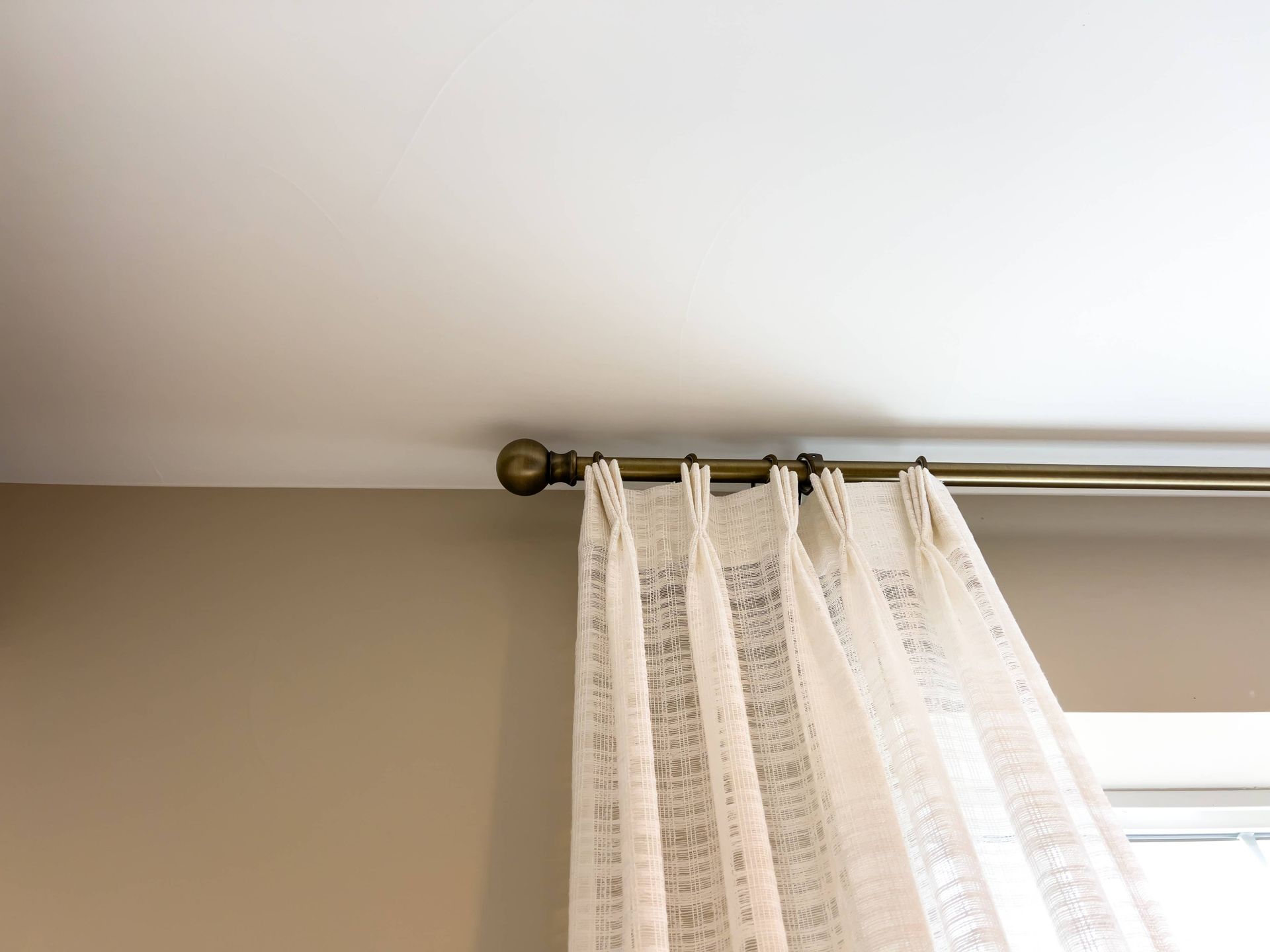 Stunning drapes on a bronzed custom drapery hardware, placed close to the ceiling for added drama  n