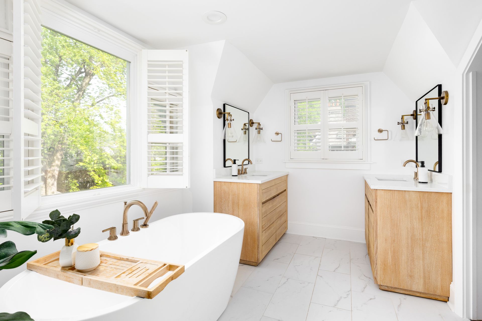 Opened custom indoor shutters on multiple windows inside a home's luxurious bathroom with bright whi