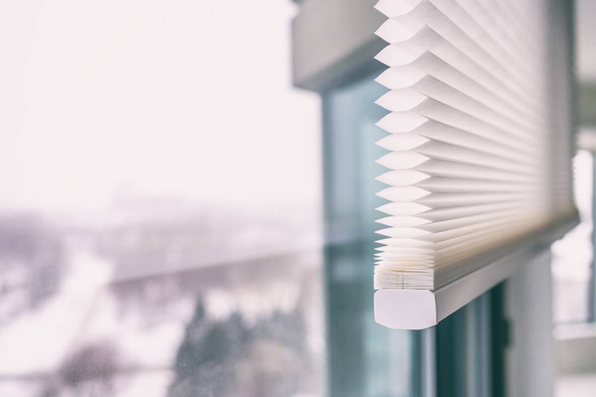 A pleated white cordless window blind on a large window overlooking an outside balcony at Window Magic Blinds & Drapery near Houston, TX