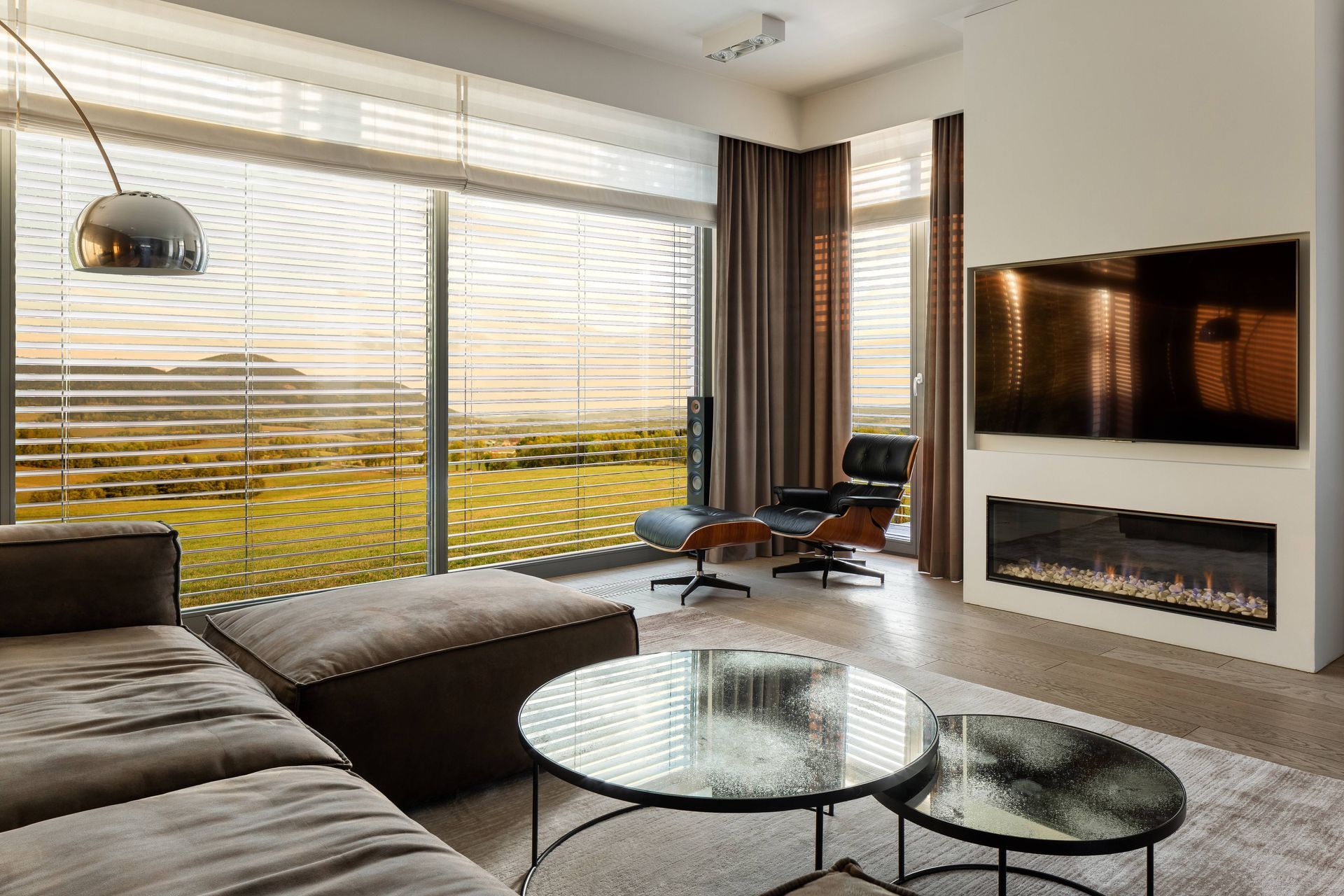 A cozy living room with sunset light streaming in through windows with blinds and drapery  at Window Magic Blinds & Drapery near Houston, TX