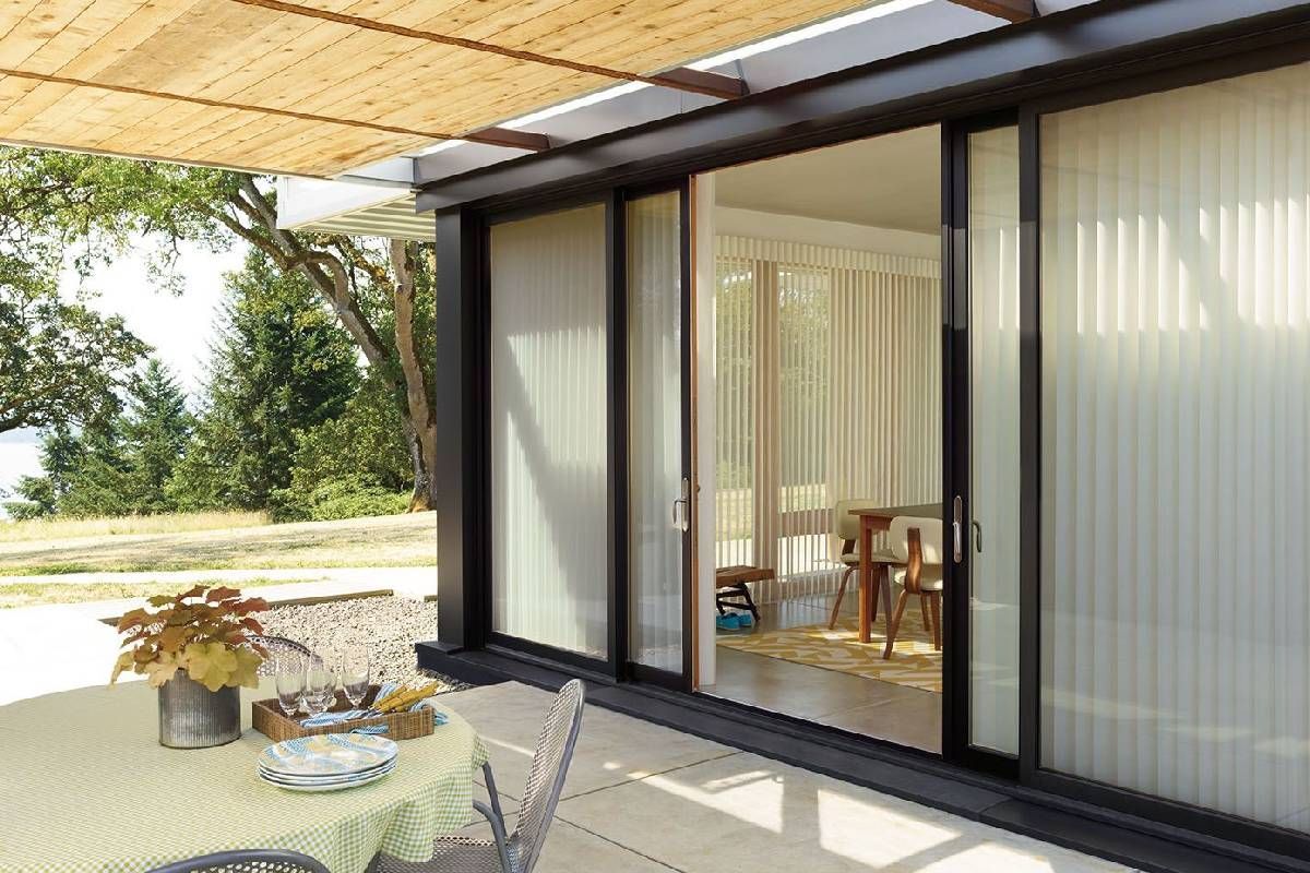 Sliding glass patio doors leading to an outdoor patio dressed with Hunter Douglas Luminette® Sheer Panels at Window Magic Blind & Drapery near Houston, TX