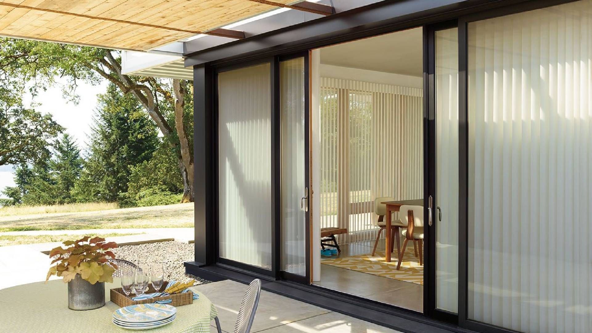 Sliding glass patio doors leading to an outdoor patio dressed with Hunter Douglas Luminette® Sheer P
