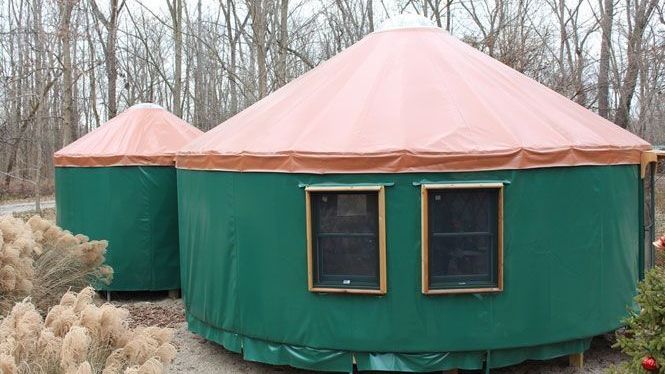 A green tent with a red roof and two windows