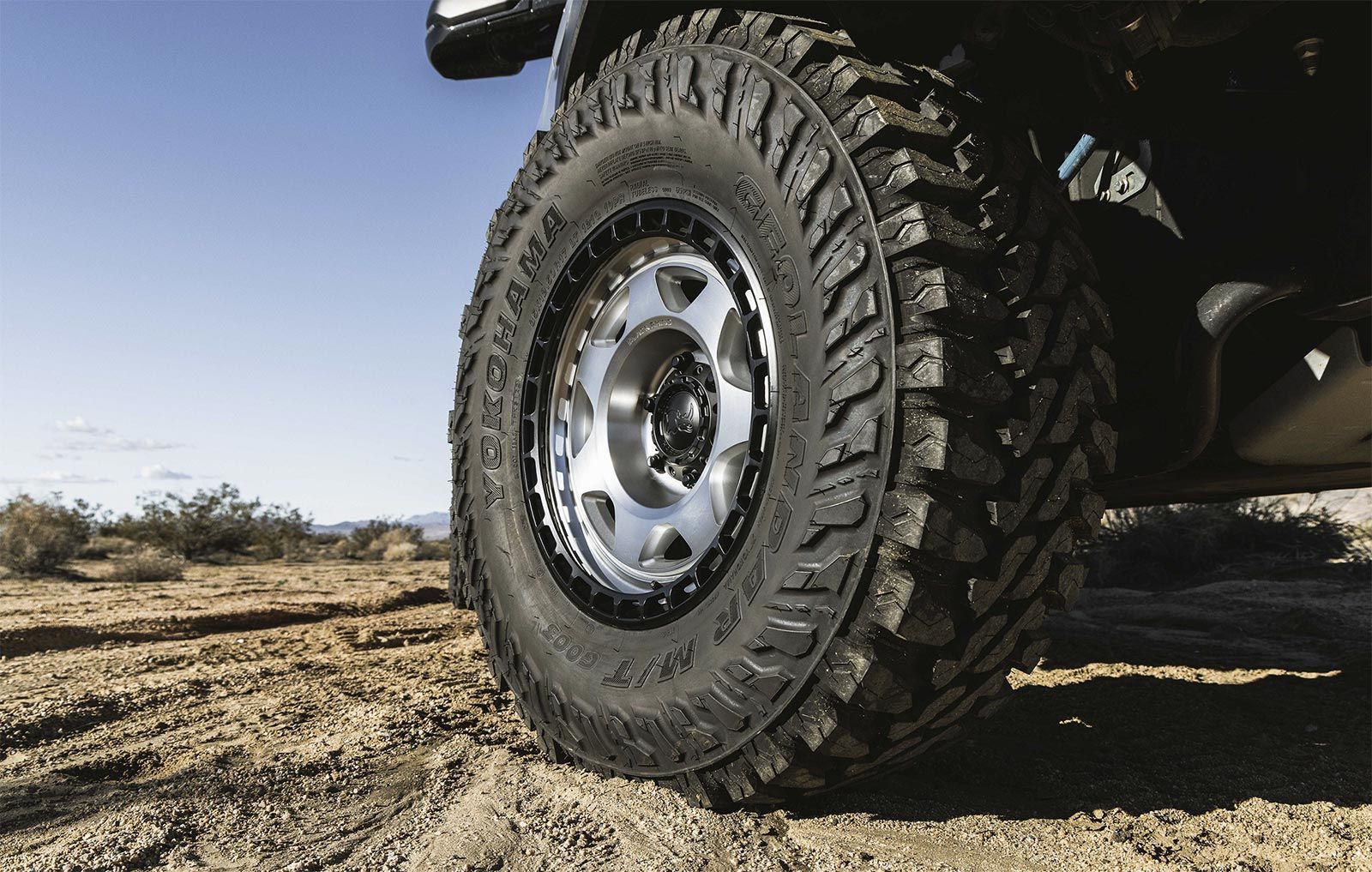 A close up of a tire on a truck in the desert