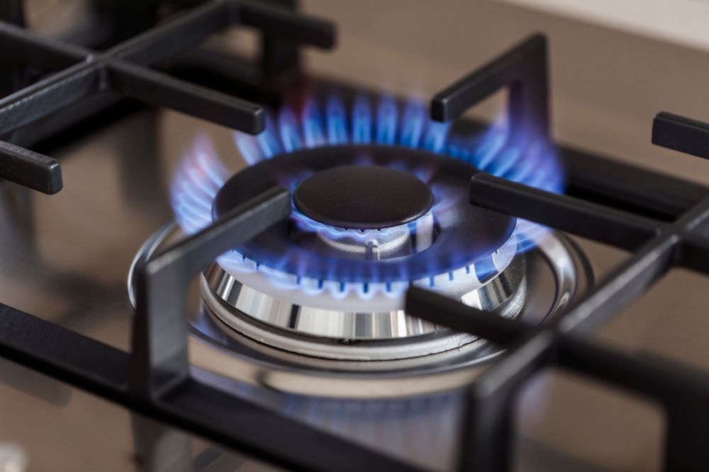 Blue Gas Flame on A Stovetop Burner in A Kitchen — Port Macquarie Plumbing In Port Macquarie, NSW