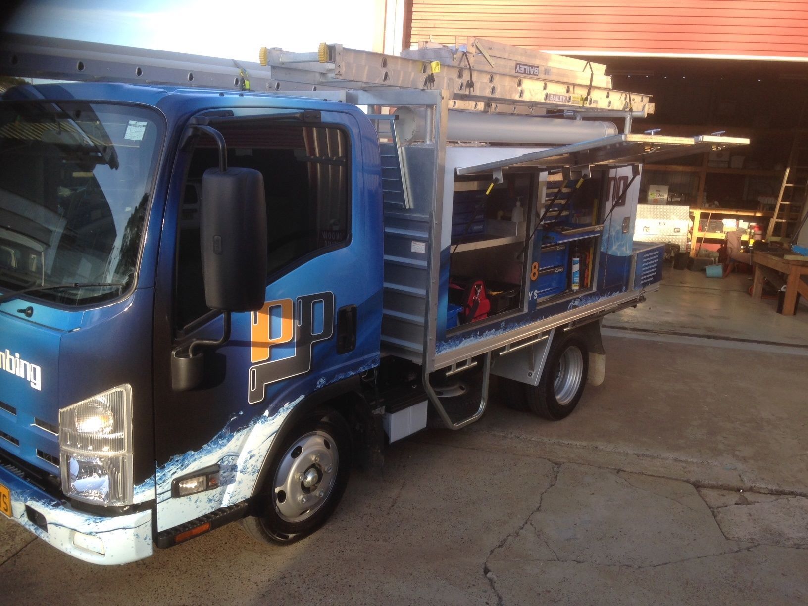 Blue Work Truck With Open Side Storage Containing Tools — Port Macquarie Plumbing In Laurieton, NSW