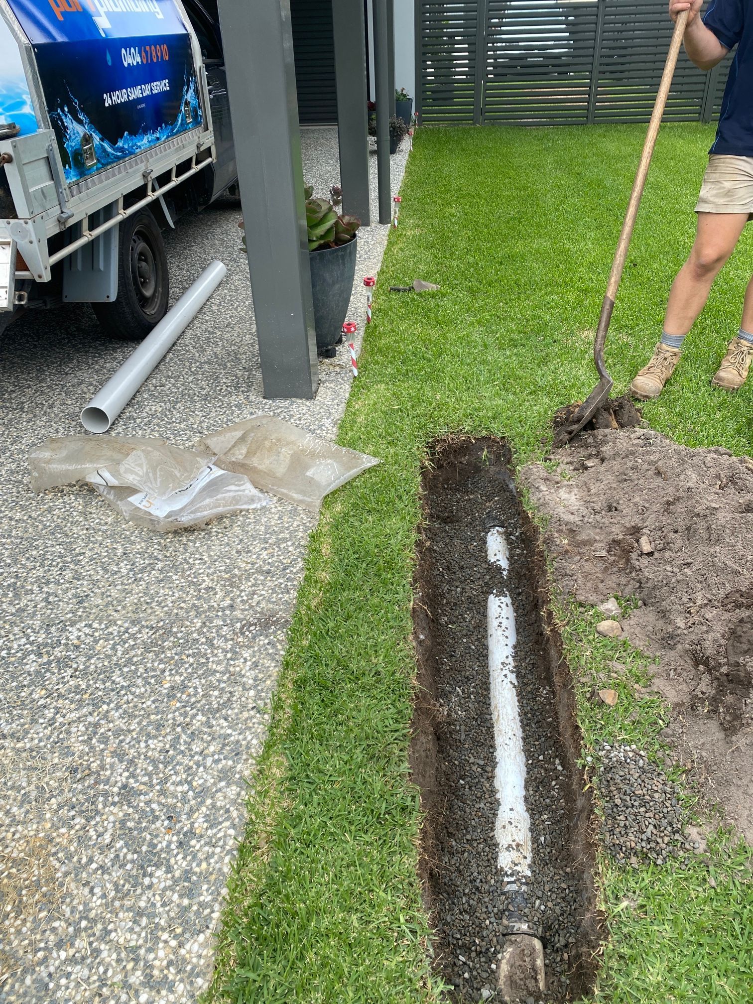 Workers Digging a Trench Beside a Gravel Driveway for A Buried Pipe Line — Port Macquarie Plumbing In Laurieton, NSW