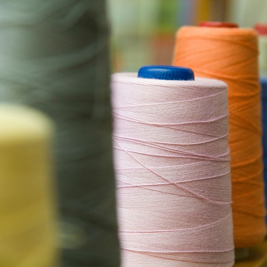 A bunch of spools of thread are sitting on a table.