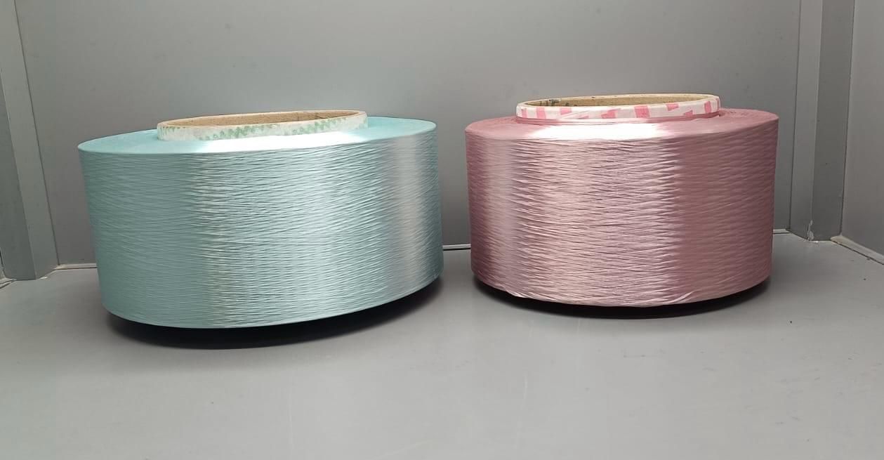 There are many rolls of copper wire stacked on top of each other in a factory.