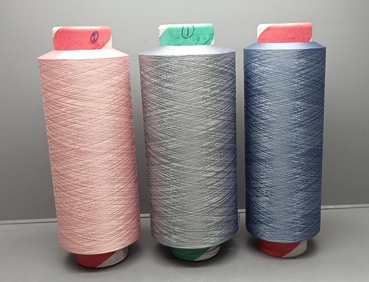 Three spools of thread are lined up next to each other on a white background.