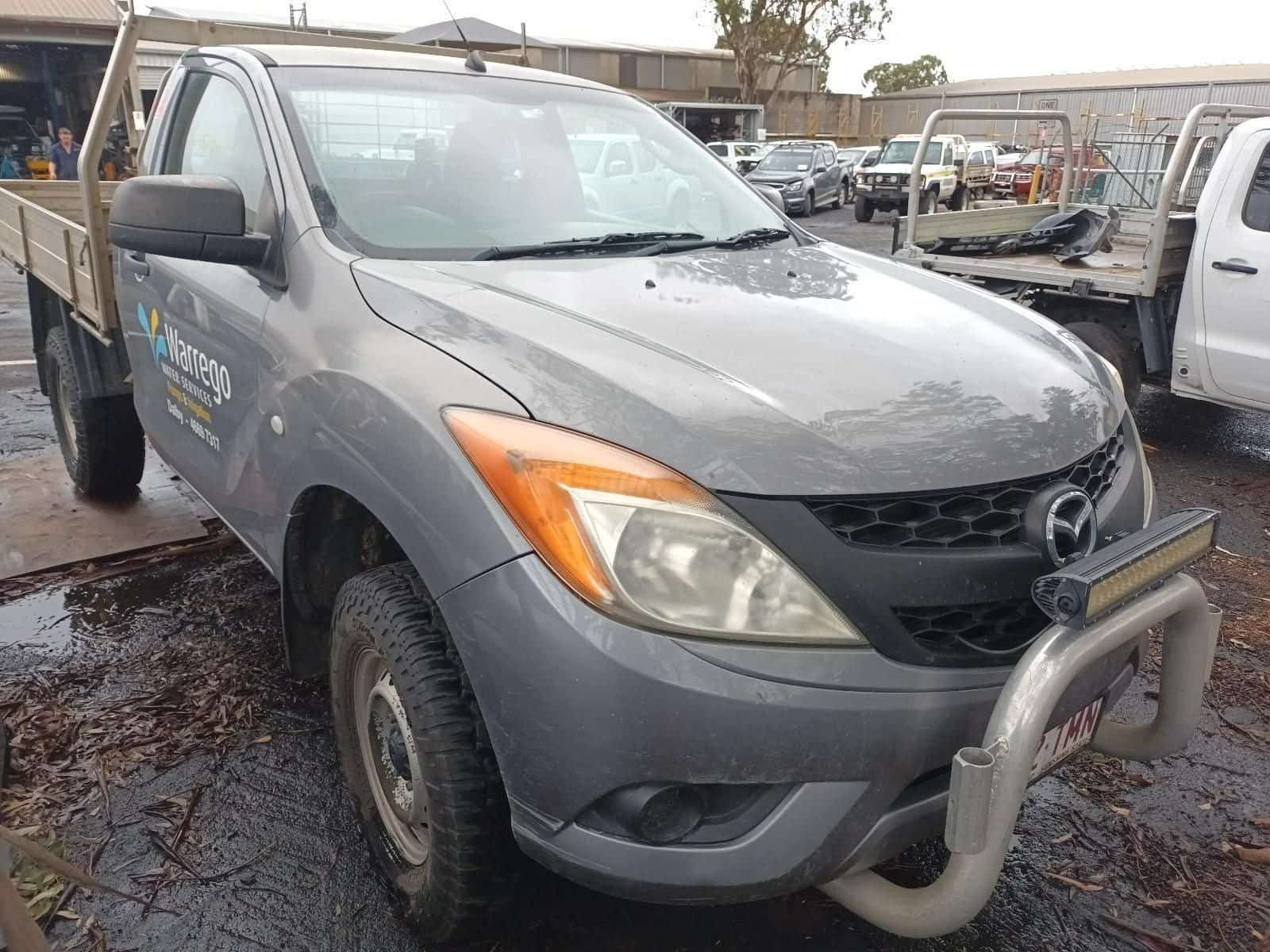 A Gray Truck with a Flat Bed is Parked in a Parking Lot — South West 4WD Wreckers in Harristown, QLD 