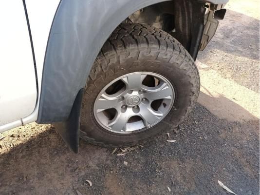 A White Truck With a Flat Tire is Parked on the Side of the Road — South West 4WD Wreckers In Harristown, QLD