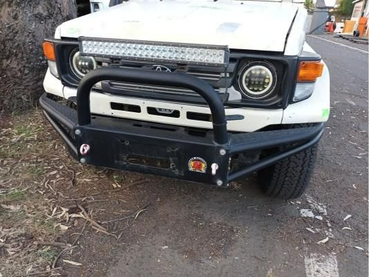 A White Truck With a Black Bumper is Parked on the Side of the Road — South West 4WD Wreckers In Brisbane, QLD