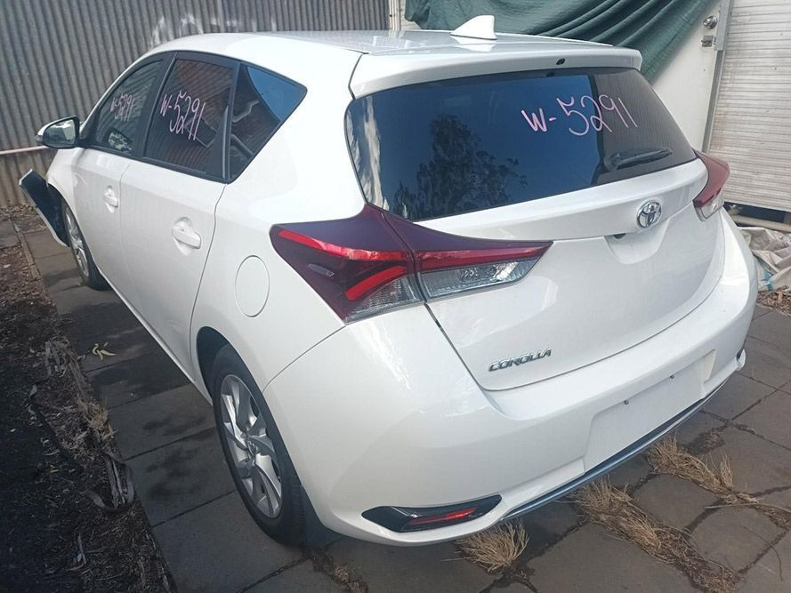 A White Toyota Corolla is Parked in Front of a Building — South West 4WD Wreckers in Harristown, QLD