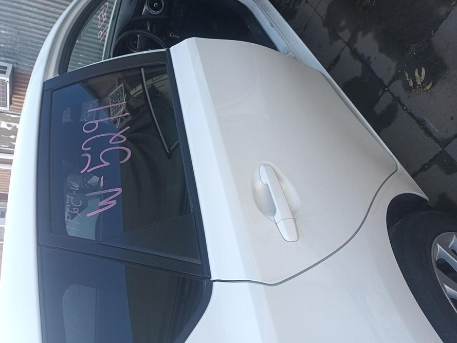 A White Car with a Black Door is Parked on the Side of the Road — South West 4WD Wreckers in Harristown, QLD