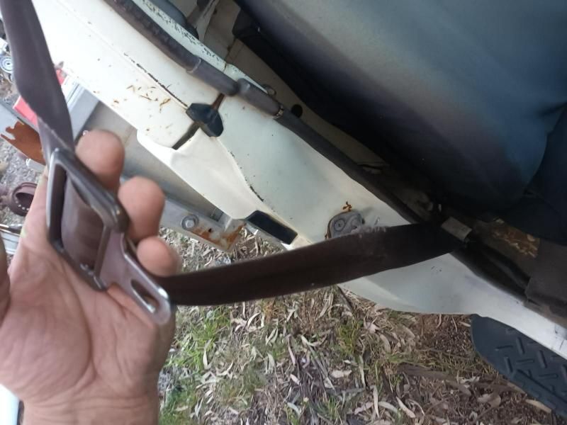 A Person is Holding a Seat Belt in Front of a Car — South West 4WD Wreckers In Brisbane, QLD