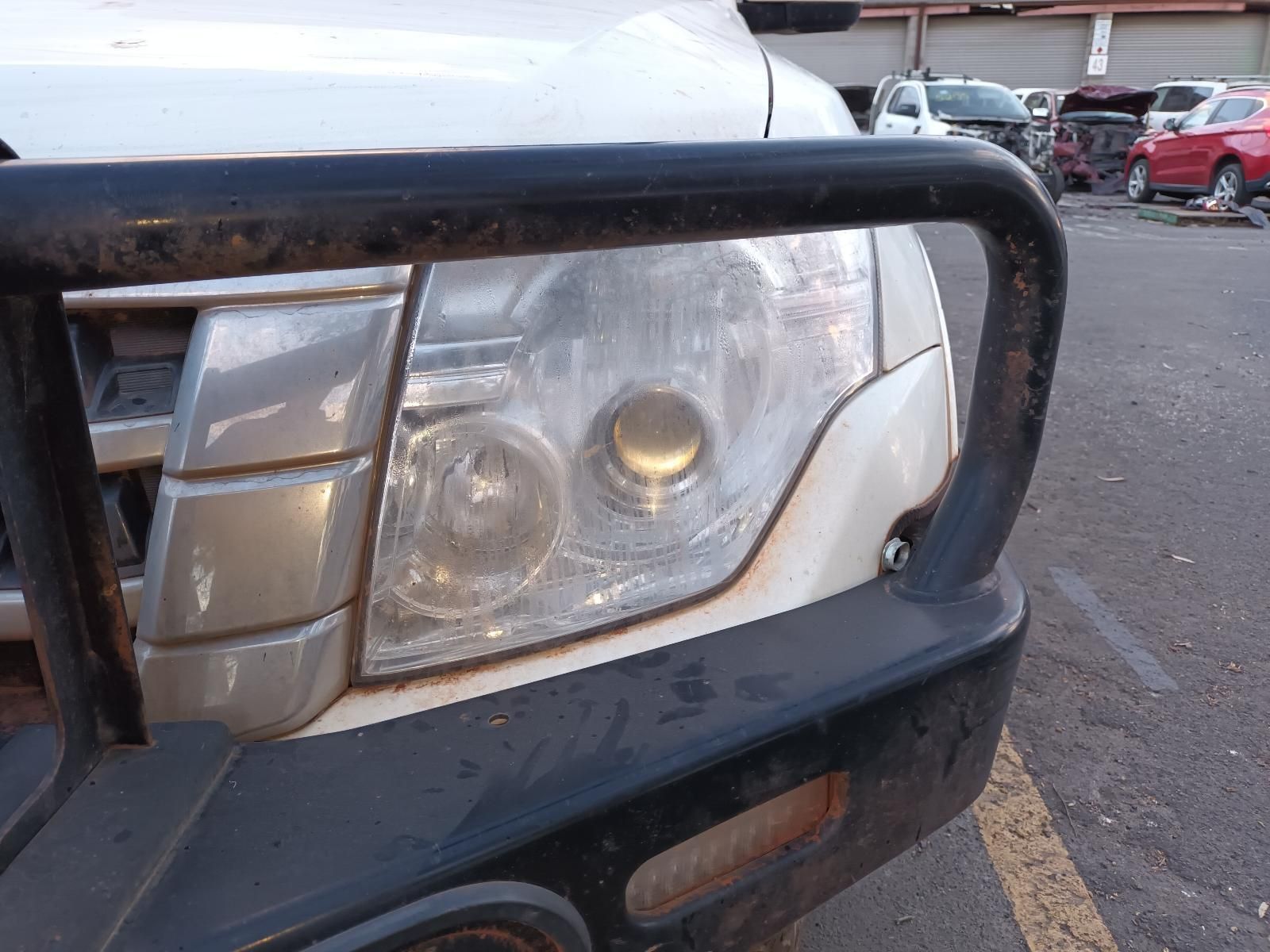 A Close Up of a Cars Headlight in a Parking Lot — South West 4WD Wreckers In Brisbane, QLD