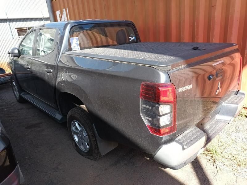 A Gray Truck With a Black Bed Cover is Parked in Front of a Red Container — South West 4WD Wreckers In Harristown, QLD