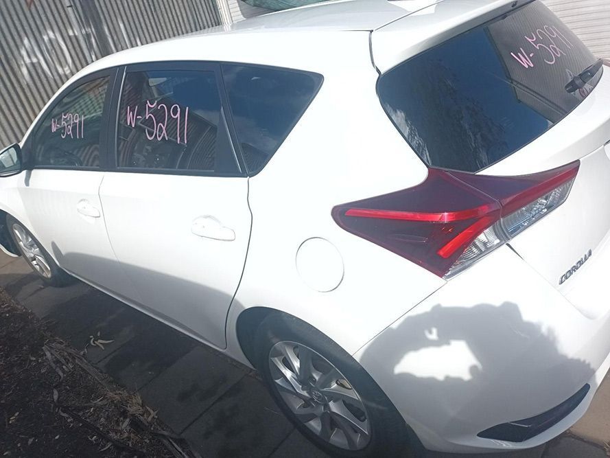 A White Car with a Red Tail Light is Parked in Front of a Fence — South West 4WD Wreckers in Harristown, QLD