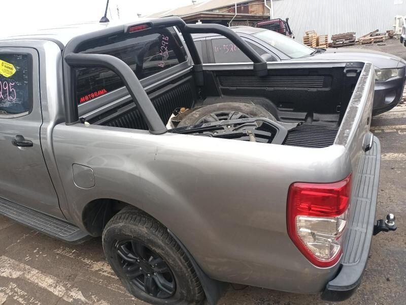 A Silver Truck With a Spare Tire in the Bed is Parked in a Parking Lot — South West 4WD Wreckers In Harristown, QLD